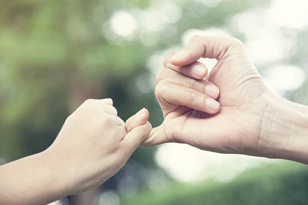 istock mother and her child hooking their fingers 585588400