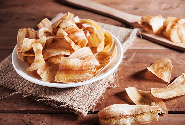 istock Banana chips in white plate in still life tone 585590940
