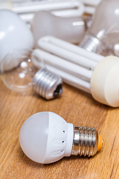 istock new LED lamp and pile of old bulbs on board 585591072