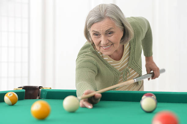 istock Mature woman Playing billiard 585591136