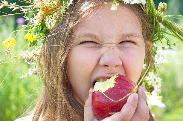 маленькая счастливая девочка ест большое красное яблоко - apple eating little girls green стоковые фото и изображения