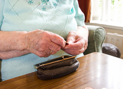 Elderly woman checking her purse for cash
