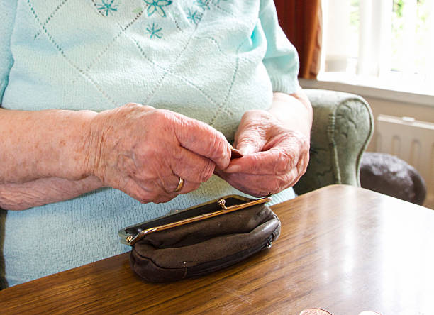 Elderly woman checking her purse for cash stock photo