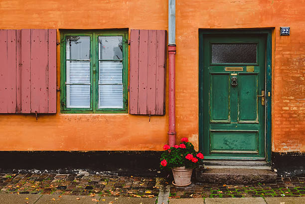 orange wall, green windows and red flower pot - denmark copenhagen brick street imagens e fotografias de stock