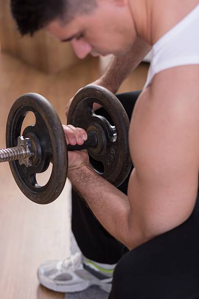 istock Athletic male holding dumbbells 585597892