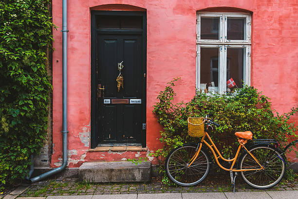 orange bike pochylił się do czerwonej ściany w kopenhadze - denmark copenhagen brick street zdjęcia i obrazy z banku zdjęć