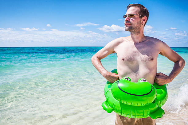 Man with inflatable beach toy on vacation in the Bahamas.