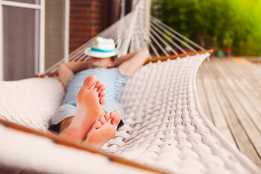 Lazy time. Man in hat in a hammock on a summer day