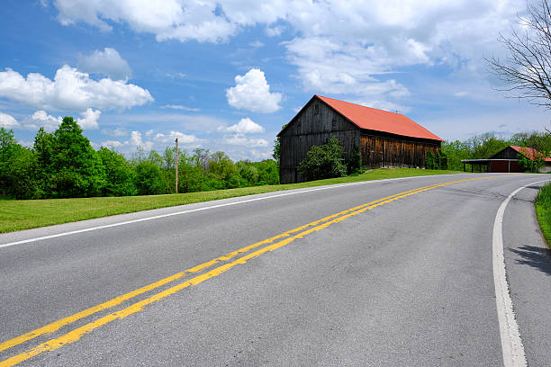 istock Old red roof barn near highway 585601478