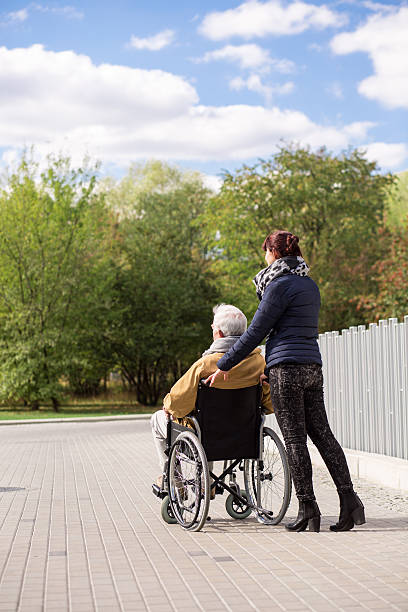 istock Man on wheelchair with nurse 585601954
