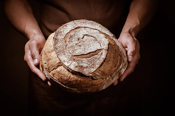 丸いパンを持っているベーカーマン - soda bread bread brown bread loaf of bread ストックフォトと画像