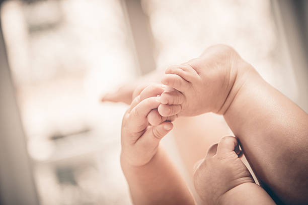 istock Baby holds his small hands their feet close-up 585604840
