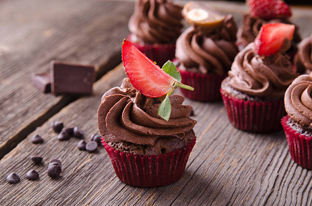 istock Chocolate cupcakes with strawberry and  on a wooden table. 585607462