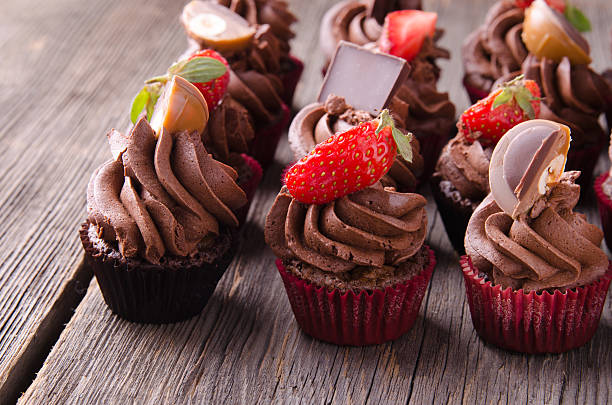 istock Chocolate cupcakes with strawberry and  on a wooden table. 585607542