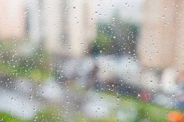 istock raindrops on window and blurred houses 585607818