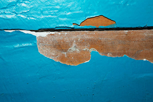 Wooden wall with peeling paint. Paint peeling plaster walls. Old wooden painted blue rustic background, paint peeling