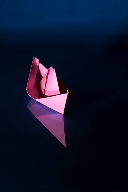 istock pink paper boat 585611398