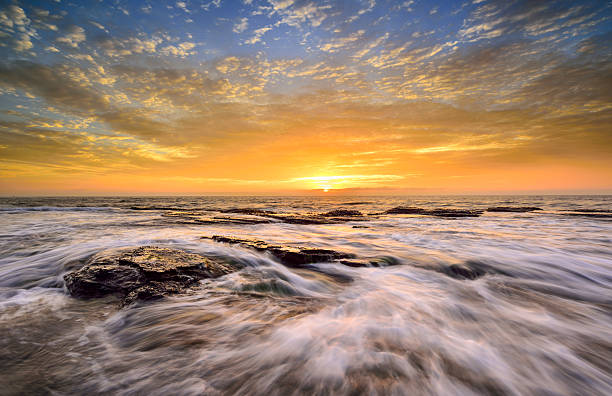 Wave flows over weathered rocks and boulders at North Narrab