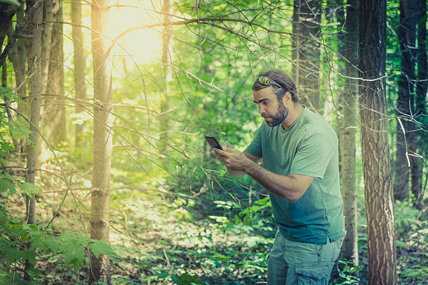istock Man Lost In Forest at Sunset and Using Smartphone 585613668