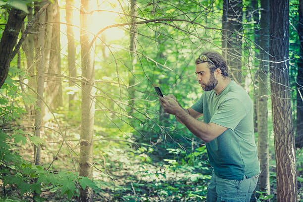 istock Man Lost In Forest at Sunset and Using Smartphone 585613678