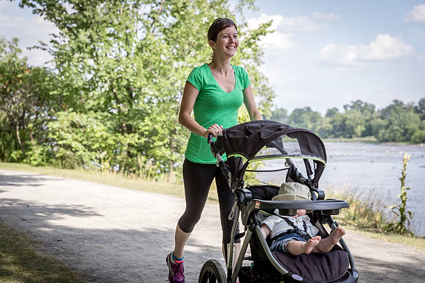 istock Mother Running Walking With baby Stroller in Park 585613850