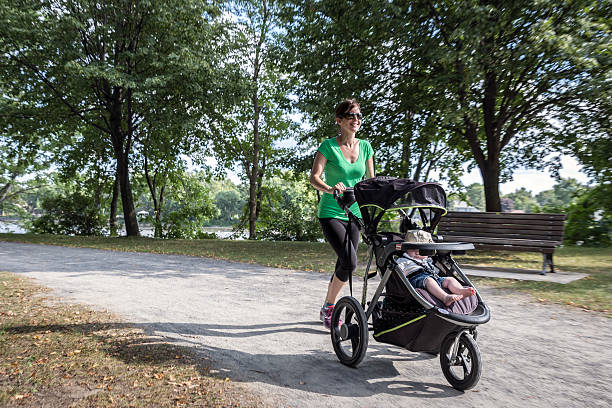istock Mother Running Walking With baby Stroller in Park 585613860