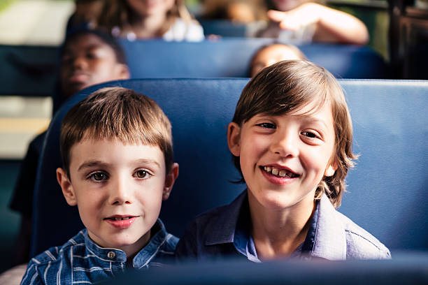istock Portrait of two candid elementary age boys on school bus. 585614584