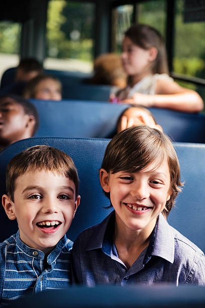 istock Portrait of two candid elementary age boys on school bus. 585614630