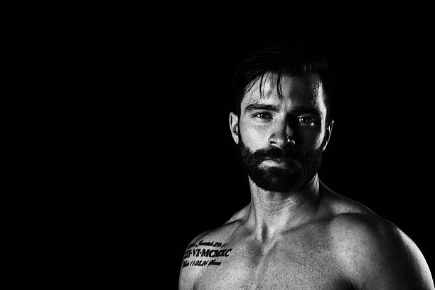 A portrait of a young man shot in noir style having an expression akin to vulnerability.