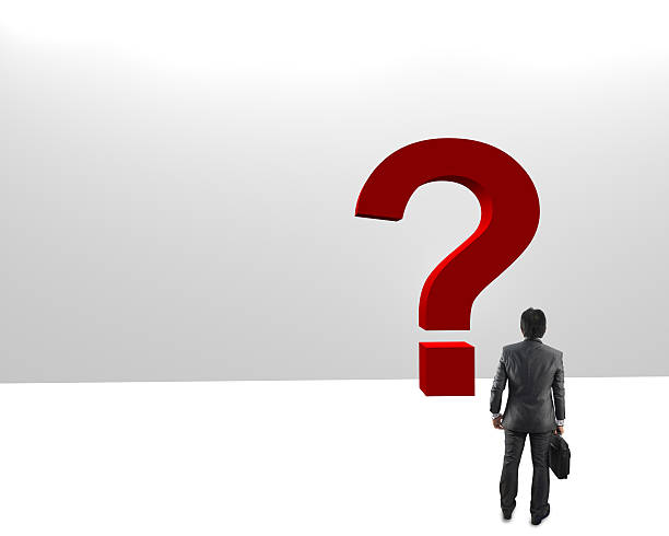 istock young businessman looking at red question marks 585617648