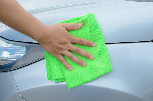istock Hand with green microfiber cloth cleaning car. 585623766