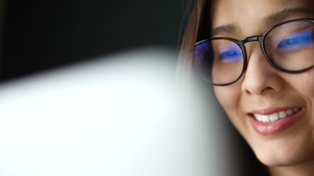 Asian Young Woman watching Information of computer screen, Reflection in glasses