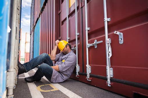 adult worker portrait in large container port, taking a nap in the shade