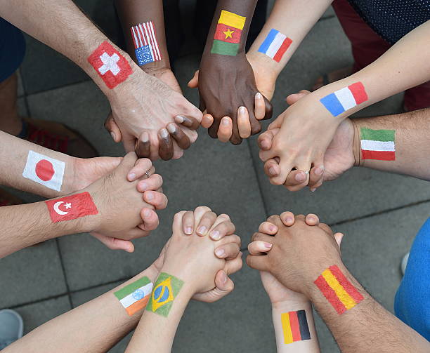 International brothers and sisters in a circle International brothers and sisters standing in a circle together and holding hands as a symbol for peace and the world community national flag photos stock pictures, royalty-free photos & images