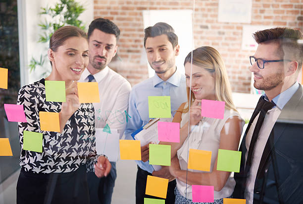 istock Team behind glass with colorful papers 585767652