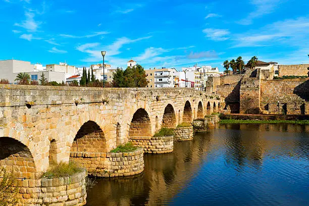 a view of the Puente Romano, an ancient Roman bridge over the Guadiana River, in Merida, Spain