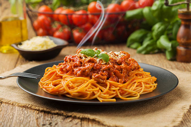 köstliche spaghetti auf schwarzem teller serviert - pasta stock-fotos und bilder