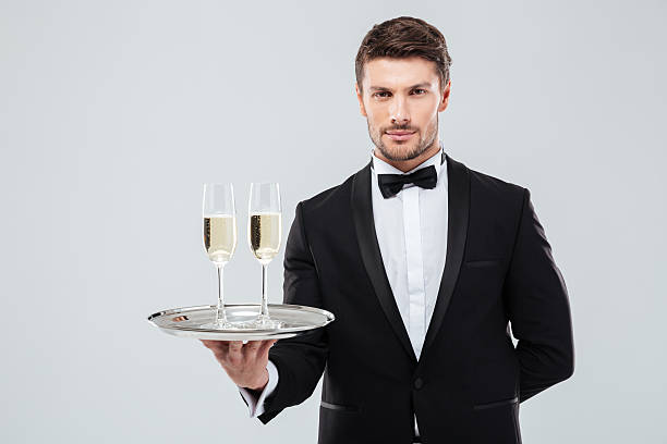 mayordomo en bandeja de esmoquin con dos copas de champán - waiter butler champagne tray fotografías e imágenes de stock