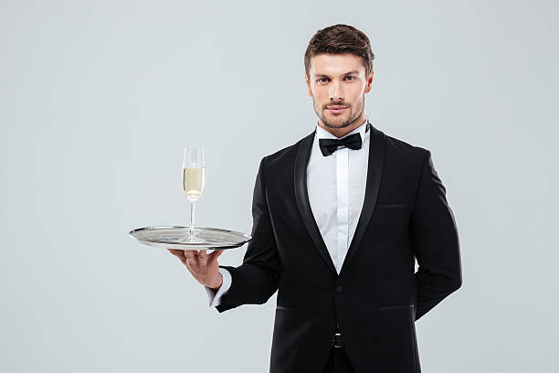 シャンパンのグラスとトレイを保持するタキシードのバトラー - butler champagne service waiter ストックフォトと画像