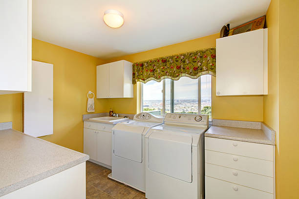 istock Old laundry room with white cabinets and yellow walls. 585771306