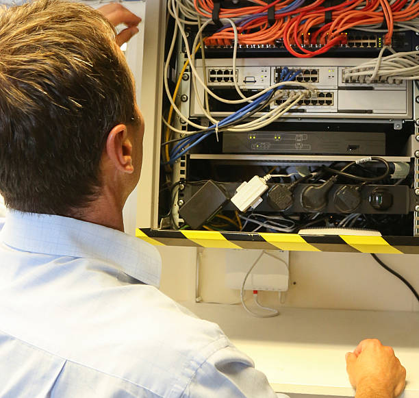 istock Telecommunication engineer installing a new network/telephone cable to a business 585772600