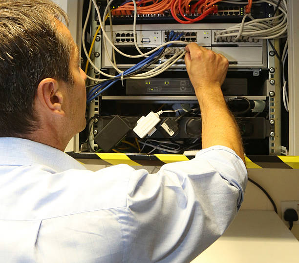istock Telecommunication engineer installing a new network/telephone cable to a business 585772616