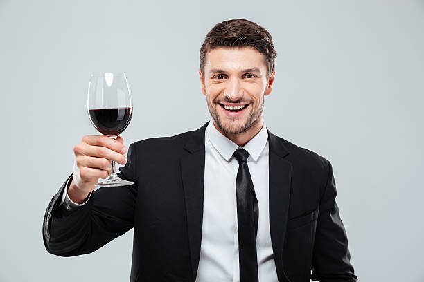 istock Cheeful young businessman smiling and drinking red wine 585773424