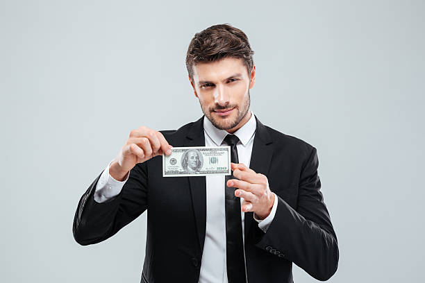 istock Attractive young businessman holding one hundred dollars banknote 585774702