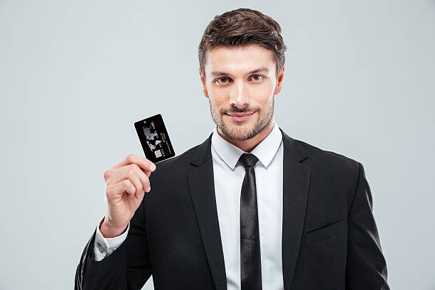 Handsome young businessman holding credit card stock photo