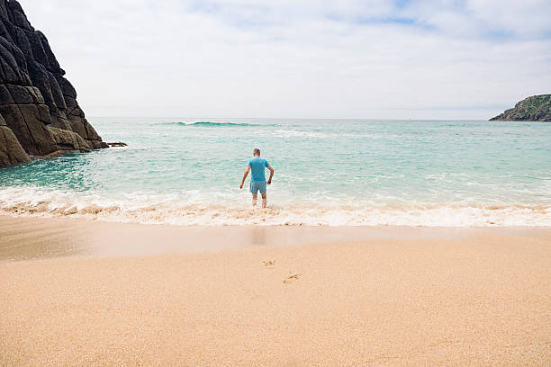istock Man paddling at Pedn Vounder Beach, Cornwall. 585776890
