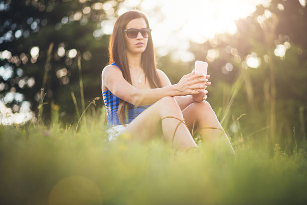 istock Young girl using phone in the nature 585779516
