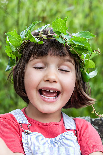 istock cute child with green leaf crown singing with eyes closed 585784756