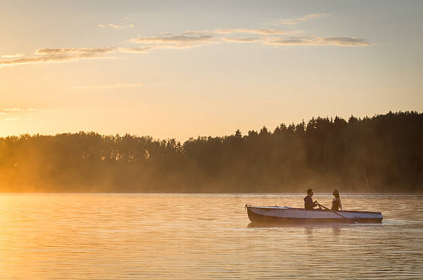 istock Romantic golden river sunset. Couple on boat backlit by sunlight 585785928