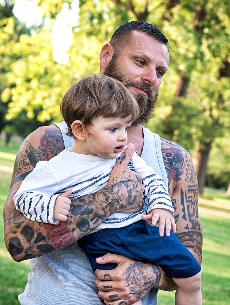 istock Tattooed Father Embracing Son 585786104